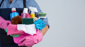young-girl-is-holding-cleaning-product-gloves-and-rags-in-the-basin-on-white-wall